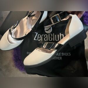 Size 11, black and white tuxedo styles flats with ankle buckle. Brand new.